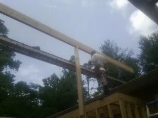Carpenter setting a ridge beam over a new addition frame — Ice Dam Removal by Roofing Brothers in Brookside